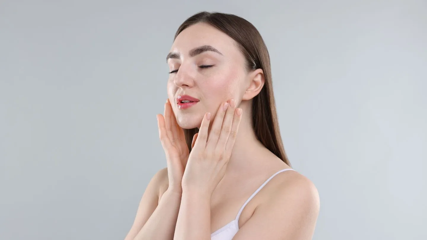 Woman Touching Face During Skincare Routine