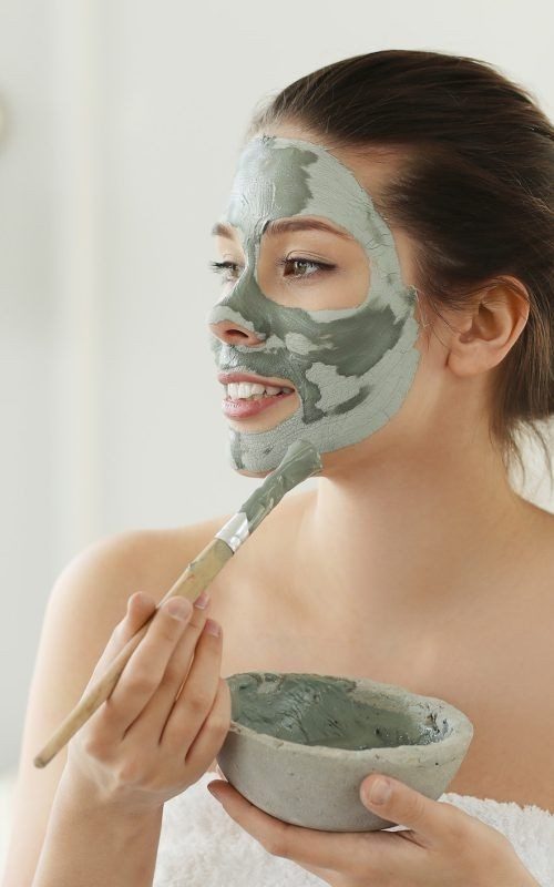 Woman Applying Mask On Her Face